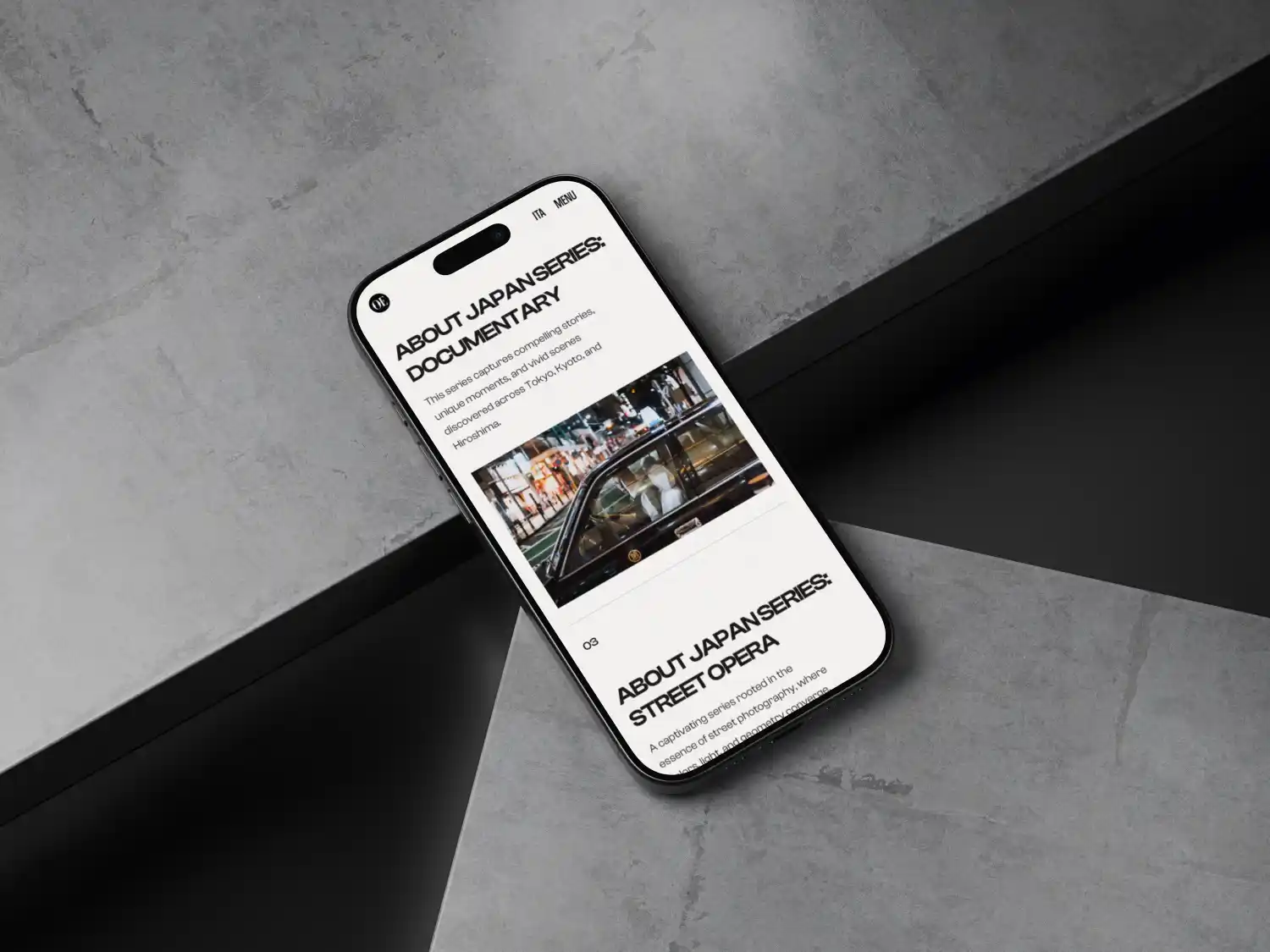 Smartphone appoggiato su una superficie in cemento che mostra una pagina web su serie documentarie giapponesi e opera di strada, con l'immagine di un'auto in una strada cittadina di notte.