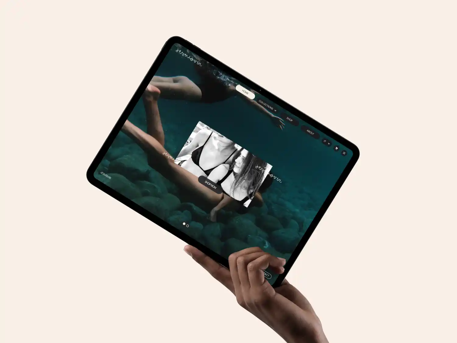 Mano che tiene un tablet che mostra un sito web di moda subacquea con modelle che nuotano e un'immagine promozionale in bianco e nero di una donna in costume da bagno con il pulsante 'Acquista ora'.